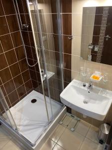 y baño con ducha y lavamanos. en Penzión Sport en Košice