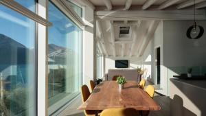 a dining room with a wooden table and yellow chairs at Italianway - Villa Paloma in Marone