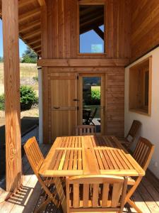 - une table et des chaises en bois sur la terrasse couverte d'une cabine dans l'établissement Prestigious Chalet, à Saint-Gervais-les-Bains