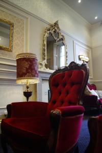 a living room with a red chair and a mirror at The Bulkeley Hotel in Beaumaris