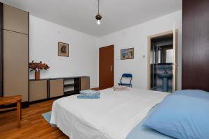 1 dormitorio con cama, escritorio y silla en Apartments Vele, en Makarska
