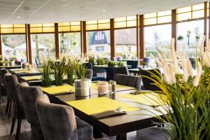 un restaurant avec des tables, des chaises et des plantes dans l'établissement Hotel Nes, à Nes