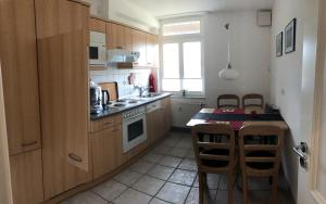 a kitchen with wooden cabinets and a table with chairs at Refugium Raabenhorst im Landhaus am Haff in Stolpe auf Usedom