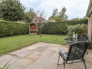 un patio con tavolo e sedie in un cortile di Humble Bee Cottage a Great Driffield