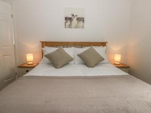 una camera da letto con un letto con due lampade su due tavoli di Humble Bee Cottage a Great Driffield