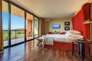 a bedroom with a large bed and a large window at NAU Morgado Golf & Country Club in Portimão