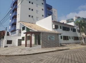 a building on the side of a street with tall buildings at Pousada Chilli Brasil in Ubatuba