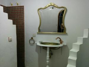 bagno con lavandino e specchio di Riad Tetuanía a Tétouan