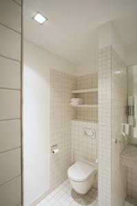 a white bathroom with a toilet and a sink at Hotel Bremer Hof in Lüneburg +12 photos