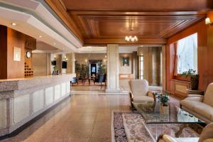 a lobby of a hotel with chairs and a bar at Ramada by Wyndham Plovdiv Trimontium in Plovdiv