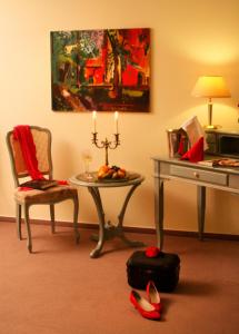 um quarto com uma mesa e uma secretária com uma vela em Hammers Landhotel GmbH em Teltow