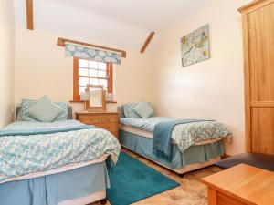 a bedroom with two beds and a window at Valley View in Helston