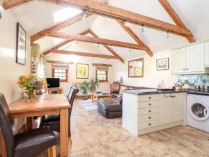 a kitchen and living room with a table and a counter at Valley View in Helston