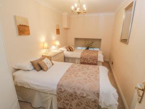 two twin beds in a room with two lamps at The Garden Apartment in Filey