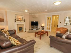 a living room with leather furniture and a fireplace at The Garden Apartment in Filey