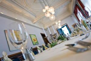 a dining room with a table with chairs and a chandelier at Hotel Deutsches Haus in Braunschweig