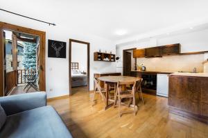 cocina y sala de estar con mesa y sillas en Esquirol Apartments, en El Tarter