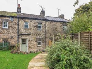 an old stone house with a garden in front of it at 5 Bank Cottage in Lancaster