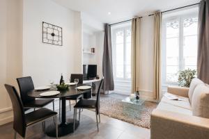 uma sala de estar com uma mesa e cadeiras e um sofá em DIFY Glamour - Place des Brotteaux em Lyon