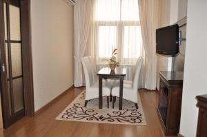 a room with a table and chairs and a television at Acapulco Hotel in Ploieşti