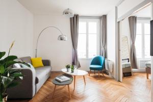a living room with a couch and a table at DIFY Cosy - Centre Ville in Lyon +2 photos