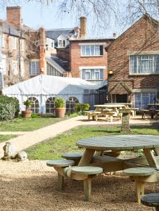 a picnic table and benches in a park at Cromwell Lodge Hotel by Greene King Inns in Banbury +26 photos