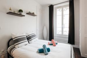 um quarto com uma cama com dois chinelos em DIFY Glamour - Place des Brotteaux em Lyon