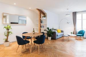 a living room with a table and chairs and a couch at DIFY Cosy - Centre Ville in Lyon