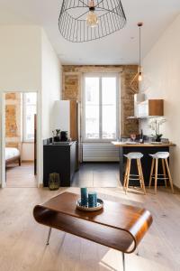 a living room with a table and a kitchen at DIFY Lumière - Masséna in Lyon