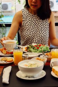 Una donna seduta a un tavolo con un piatto di cibo di Tree​ for​ rest​ poshtel a Bangkok