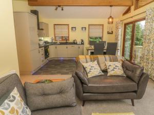 a living room with a couch and a kitchen at Nicky Nook Lodge in Preston