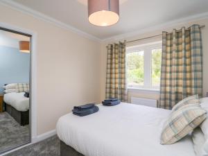 een slaapkamer met een bed met twee blauwe handdoeken erop bij Emsa House in Spean Bridge