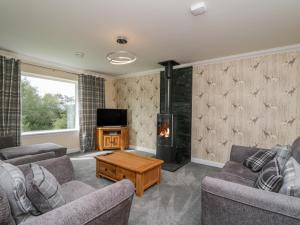 a living room with two couches and a fireplace at Emsa House in Spean Bridge