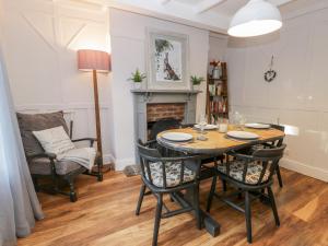 a dining room with a table and chairs and a fireplace at Rosie Cottage in Filey
