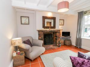 un soggiorno con camino e sedia di Rosie Cottage a Filey