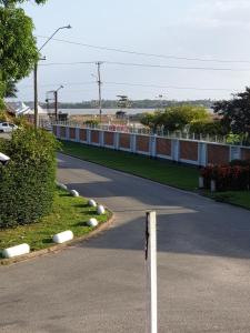 une route avec une clôture sur le côté de la route dans l'établissement Riando appartement Royal Rainville, à Paramaribo