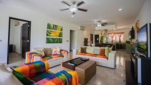 a living room with two couches and a tv at Playa Village 205 A condo in Playa del Carmen