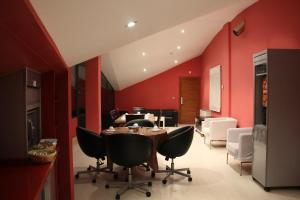 Hotel Tremazal في غواردو: غرفة طعام بجدران حمراء وطاولة وكراسي