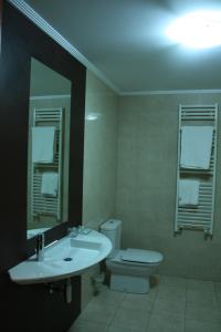a bathroom with a sink and a toilet and a mirror at Hotel Tremazal in Guardo