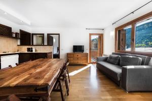 Una sala de estar con una mesa de madera y un sofá. en Apartaments Esquirol El Tarter, en El Tarter 19 fotos más