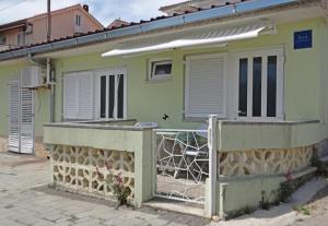 a green house with a fence in front of it at STUDIO MIMI CENTER OF TOWN KRK CROATIA in Krk