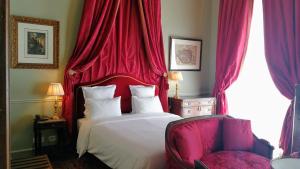 a bedroom with a bed, a chair, and a window at Hotel d'Angleterre in Paris