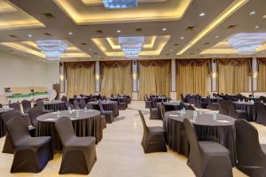 a banquet hall with tables and chairs in a ballroom at Khanvel Resort in Silvassa