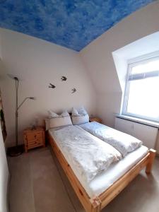 a bedroom with a bed with a blue ceiling at Ferienwohnung Elbsommer am Weinberg in Meißen
