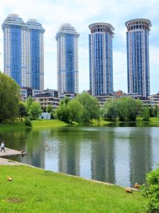 un perfil urbano con edificios altos junto a un lago en Hills Hotel апарт-отель, en Moscú