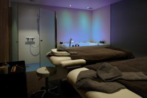 a room with three beds and a bath tub at Best Western Les Bains Hotel et SPA in Perros-Guirec