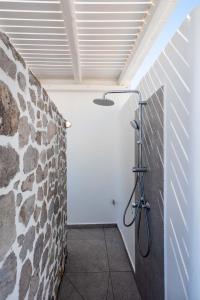 baño con pared de piedra en Luxurious stoudio in Mandrakia 1 en Mandrakia