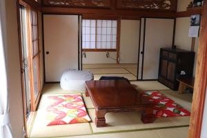 een woonkamer met een tafel en een tapijt bij Guesthouse Oyado Iizaka in Fukushima