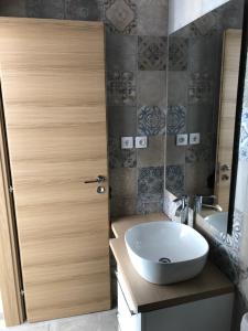 a bathroom with a white sink and a wooden door at Villa Venetia Corfu in Agnítsini +49 photos