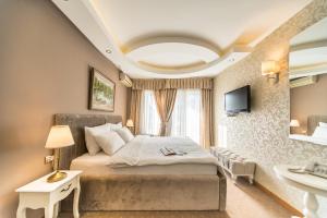 ein Schlafzimmer mit einem großen Bett und einem Waschbecken in der Unterkunft Garni Hotel President de Luxe in Kragujevac